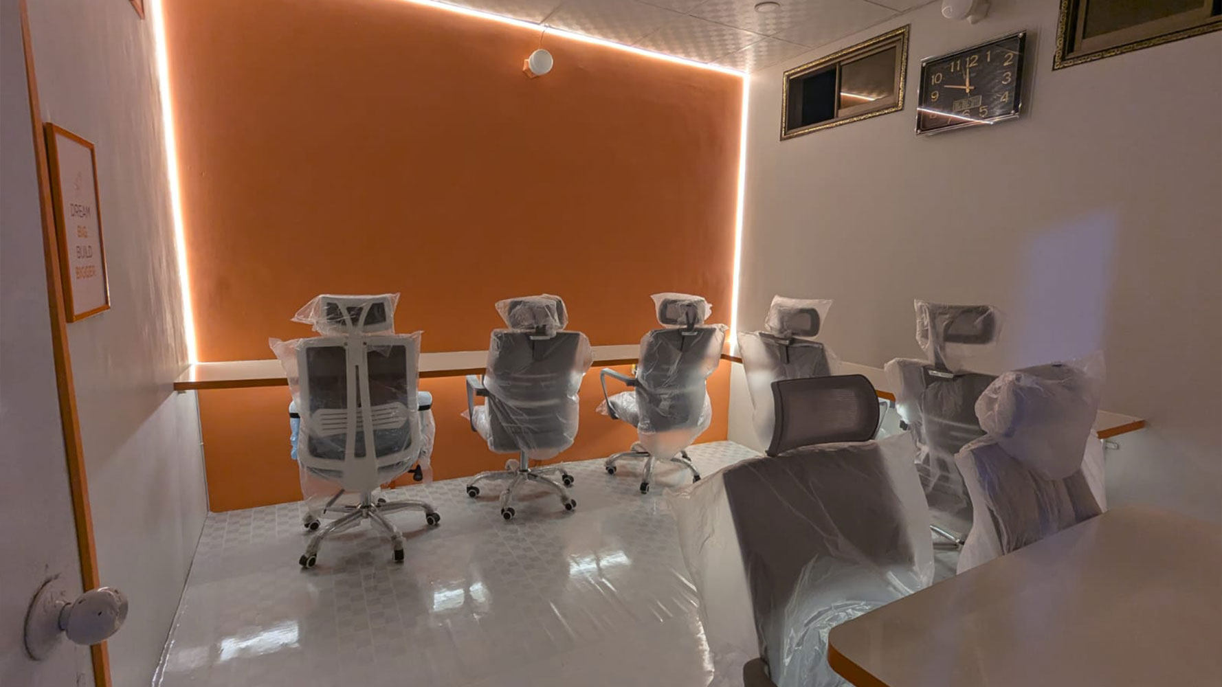 Modern corporate office room workspace featuring ergonomic office chairs and warm ambient LED ceiling lighting