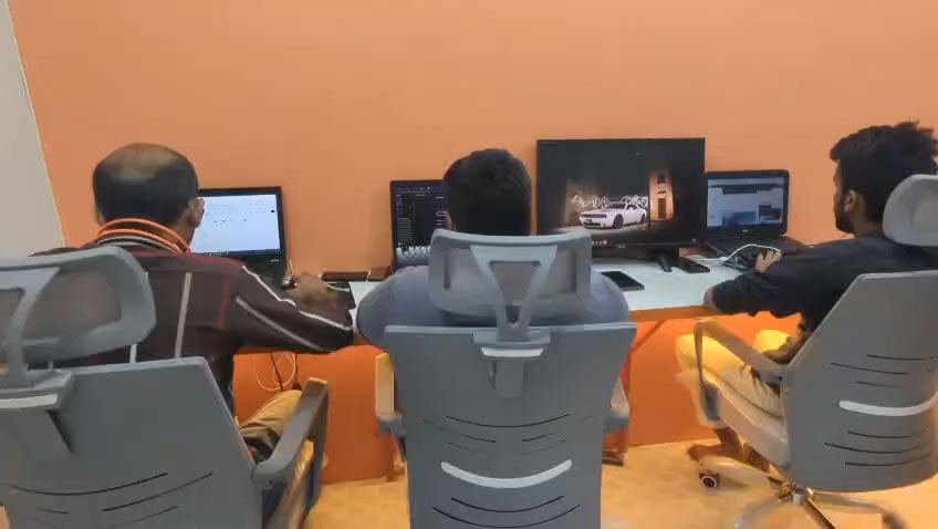 Software developer working at a dual-monitor desktop workstation in a modern tech office