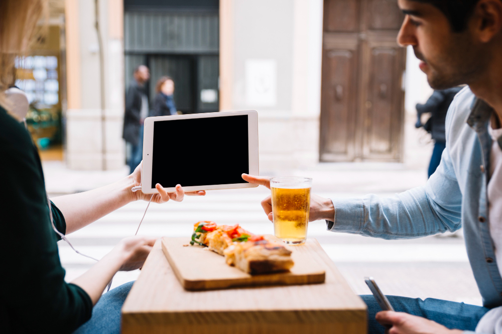 Frustrated restaurant owner holding a tablet at a table with an empty glass looking stressed