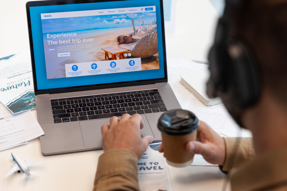 Person holding a coffee cup while browsing a tropical beach resort website on a laptop screen